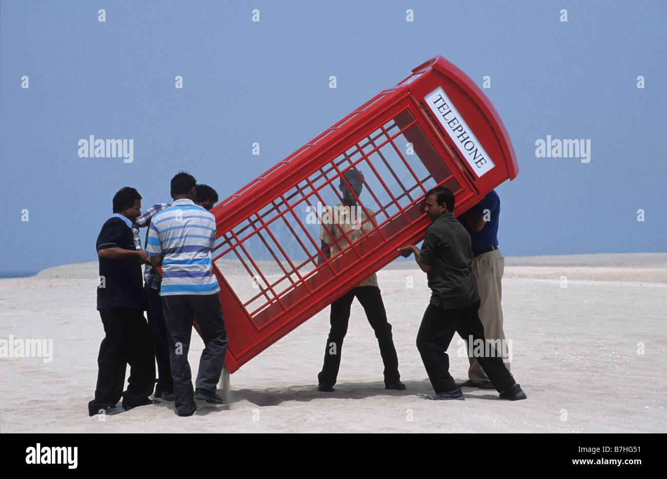 Eine traditionelle britische Telefonzelle wird in der Wüste von Dubai für ein Fotoshooting getragen. Stockfoto