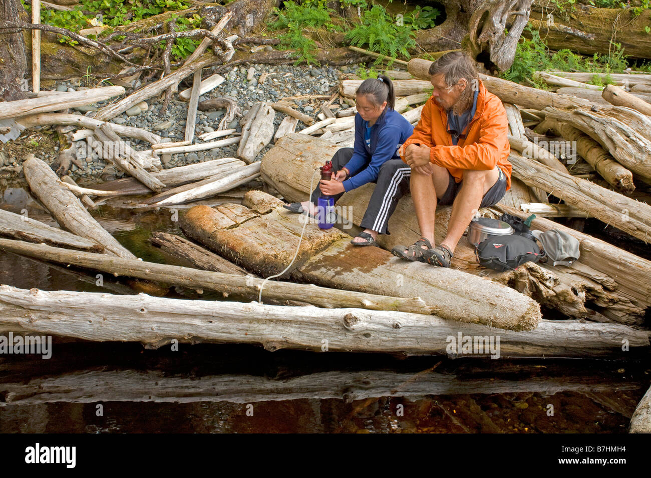 BRITISH COLUMBIA - Vater und Tochter, die Filterung von Wasser aus einem Süßwasser-Stream bei Nissen Bucht auf der North Coast Trail. Stockfoto