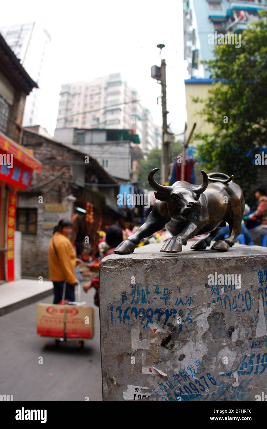 CHinas aufstrebende Wirtschaft Stier Bronze-Statue stehen auf Wand mit Werbung für gefälschte Belege und gefälschte Liscenese durring Stockfoto
