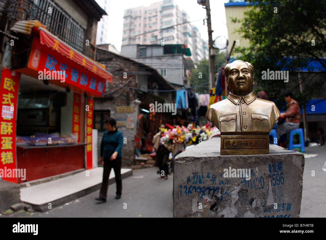 CHinas aufstrebende Wirtschaft Vorsitzender Mao Statue stehen auf Wand mit Werbung für gefälschte Belege und gefälschten Lizenzen während Stockfoto