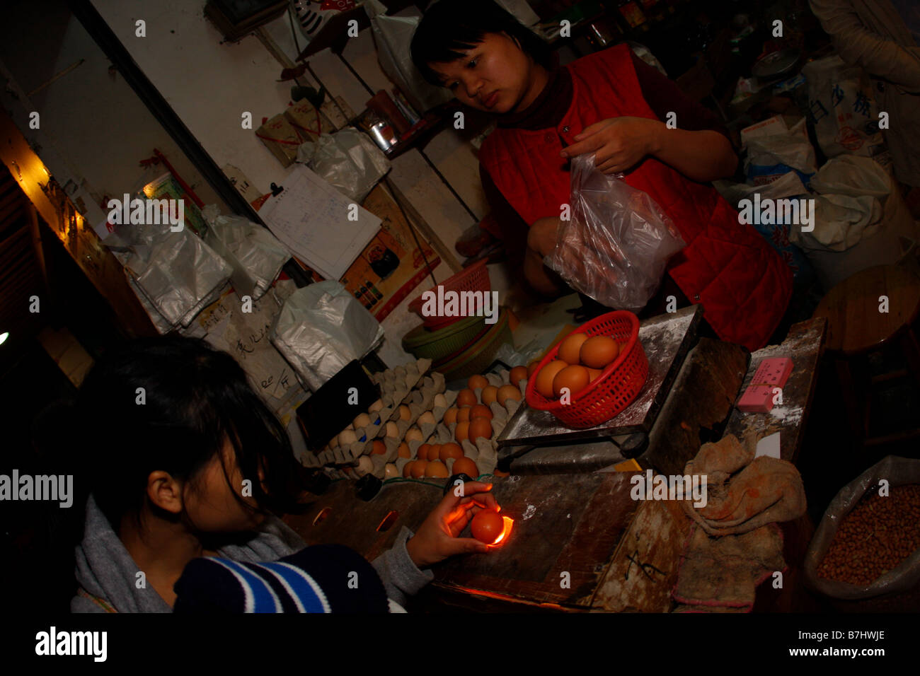 Mutter Buying Eiern von lokalen chinesischen Shop Check-Eiern auf Risse vor dem Kauf einer chinesischen tradition Stockfoto