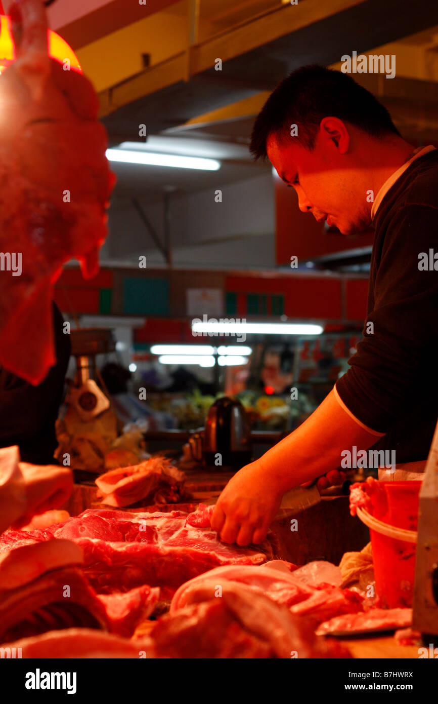 Chinesische Metzger Schneiden von Fleisch im lokalen Markt Stockfoto