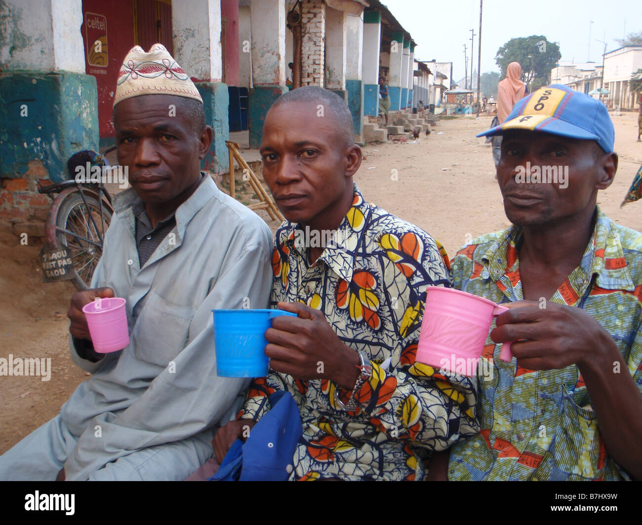 Drei ältere alte Männer trinken Tassen Tee aus Kunststoff Becher ulica Kindu demokratische Republik von Kongo Maniema Provinz Stockfoto