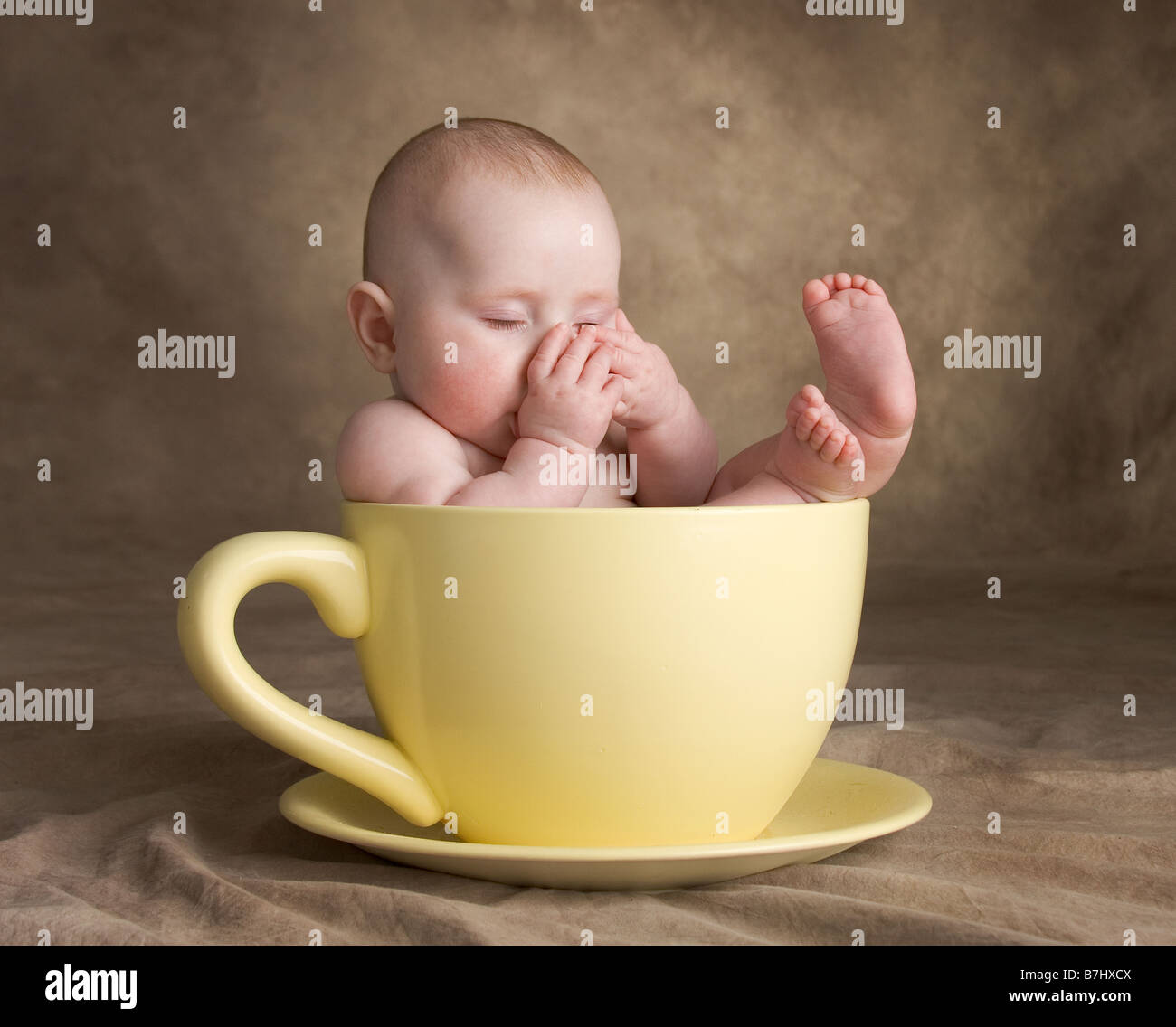 Baby schläft im Wasserglas Daumenlutschen Stockfoto