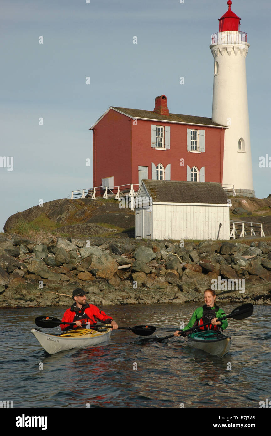 Mann (30-35) und Frau (25-30) Kajak vor einem Leuchtturm, Esquimalt, BC Stockfoto