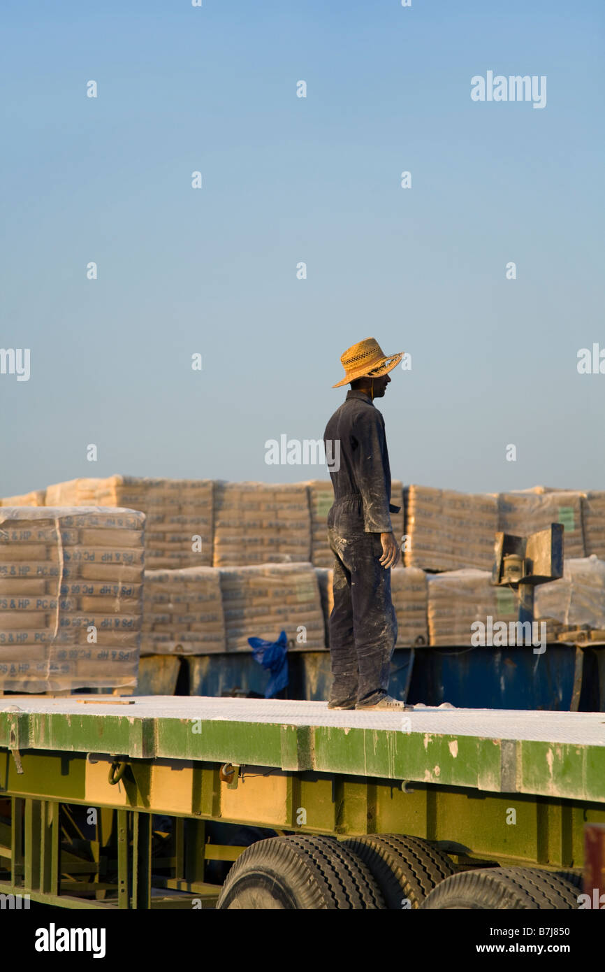 Import von Baumaterialien, Handwerker Paletten Entladen der iranischen Zement, per Schiff am Kai von Al Sharjah, Dubai, UAE geliefert Stockfoto