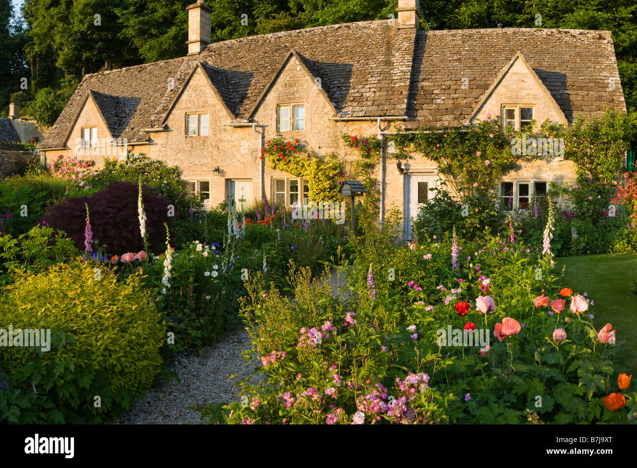 Der letzte Abend Sonnenlicht fällt auf Bauerngärten in Cotswold Dorf von Bibury, Gloucestershire Stockfoto