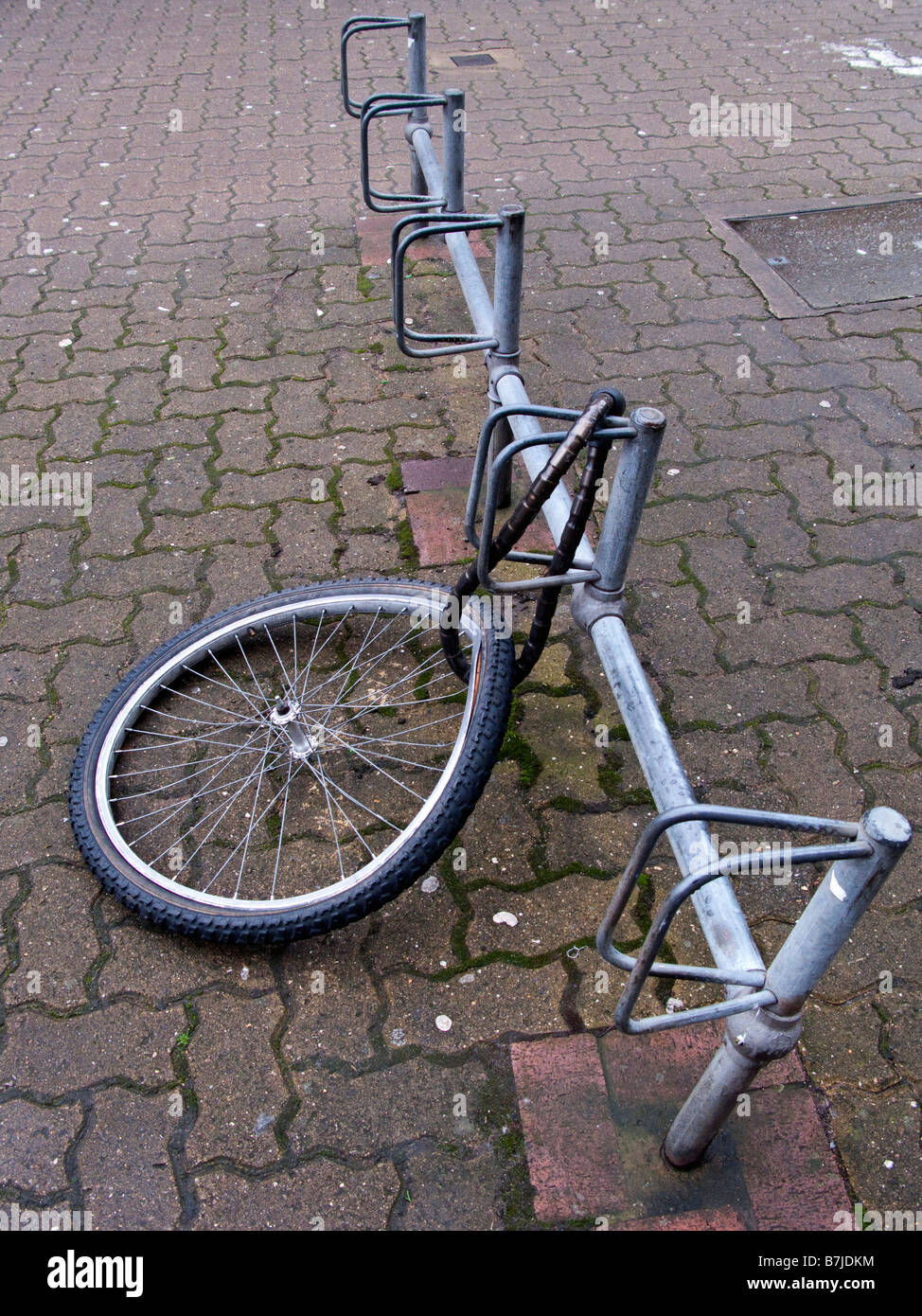 Eine beschädigtes Rad ist ein Fahrrad angekettet an einen Fahrradständer übrig ist Stockfoto