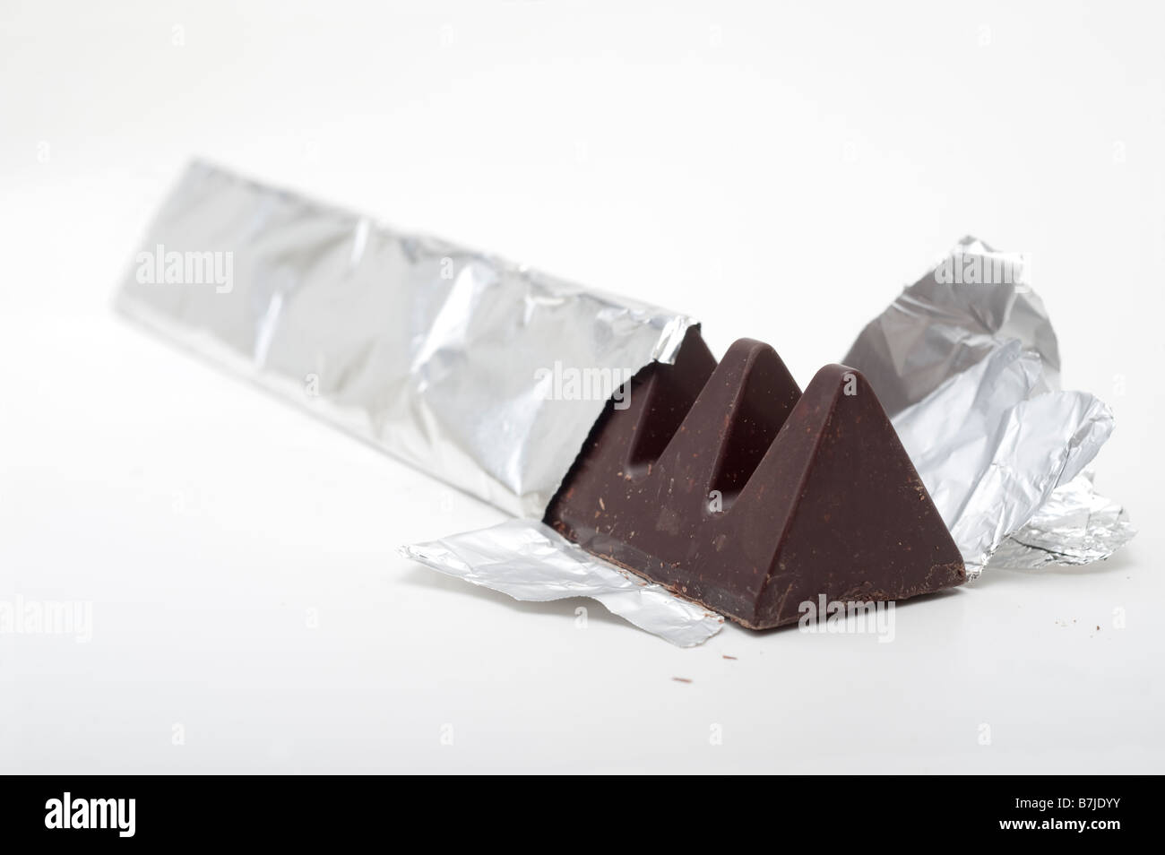 Dreieckig geformte dunkle Schokolade in Silberfolie Stockfoto
