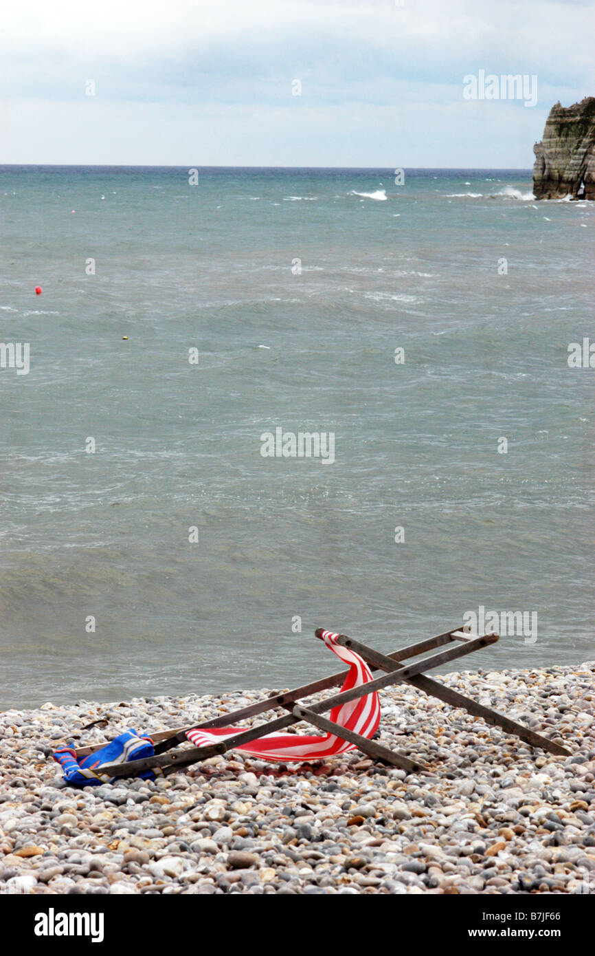 Angeschlagenen Liegestühlen an einem einsamen Strand, Maifeiertag Bankfeiertag Dorset UK Stockfoto