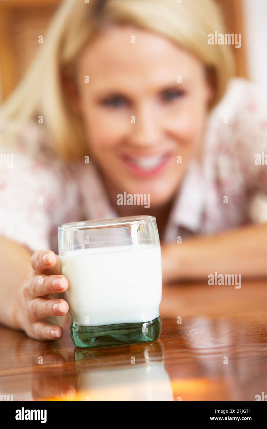 Mitte Erwachsene Frau Glas Milch, lächelnd in die Kamera halten Stockfoto