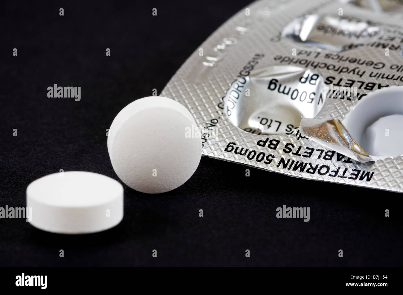 Horizontale Makro Nahaufnahme von einer Blisterverpackung von Pillen und Tabletten Metformin auf schwarzem Hintergrund Stockfoto