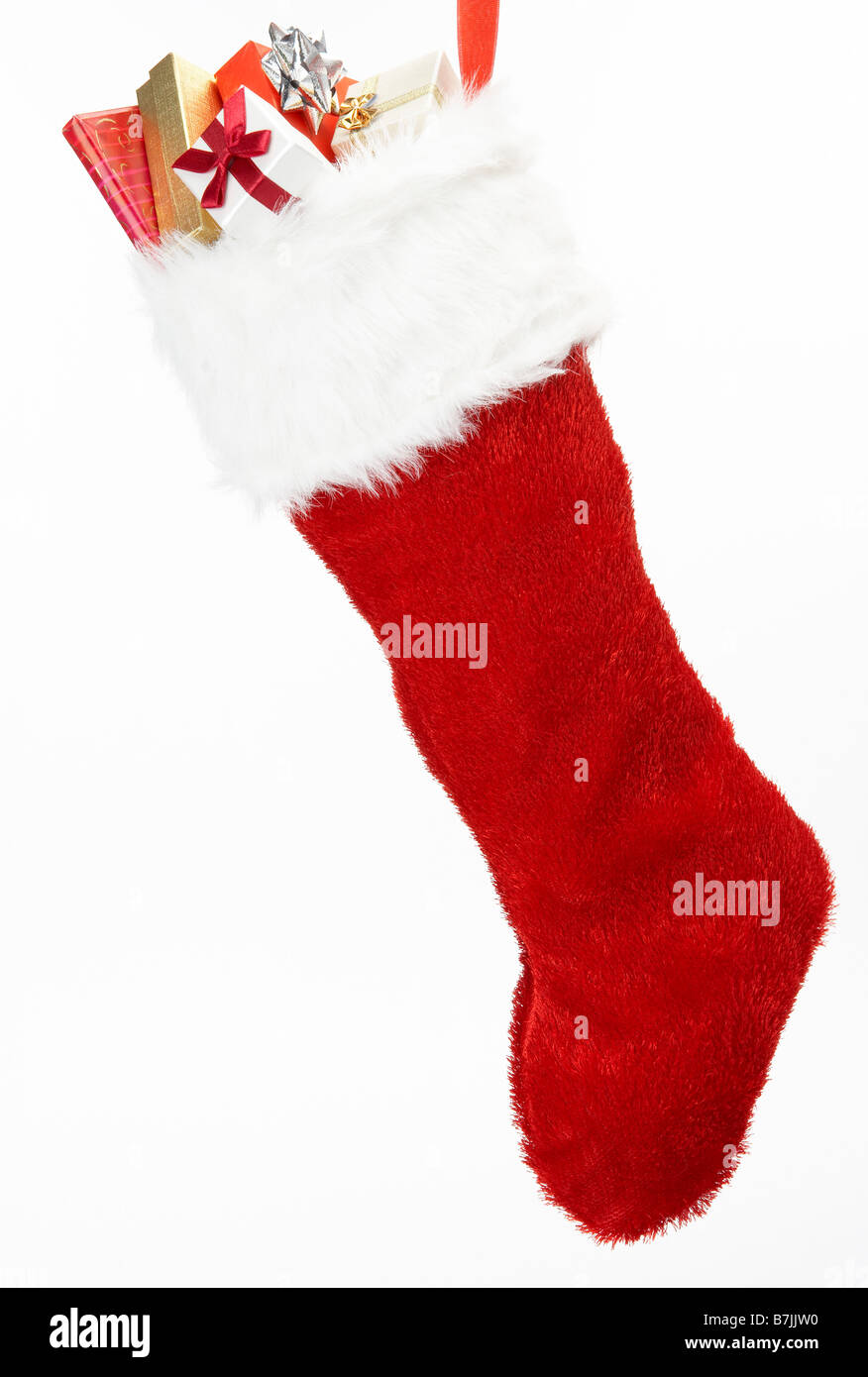 Weihnachts-Strumpf mit Geschenken vor weißem Hintergrund Stockfoto