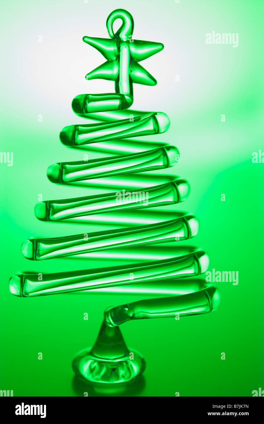 Baum-geformte Weihnachtsdekoration vor grünem Hintergrund Stockfoto