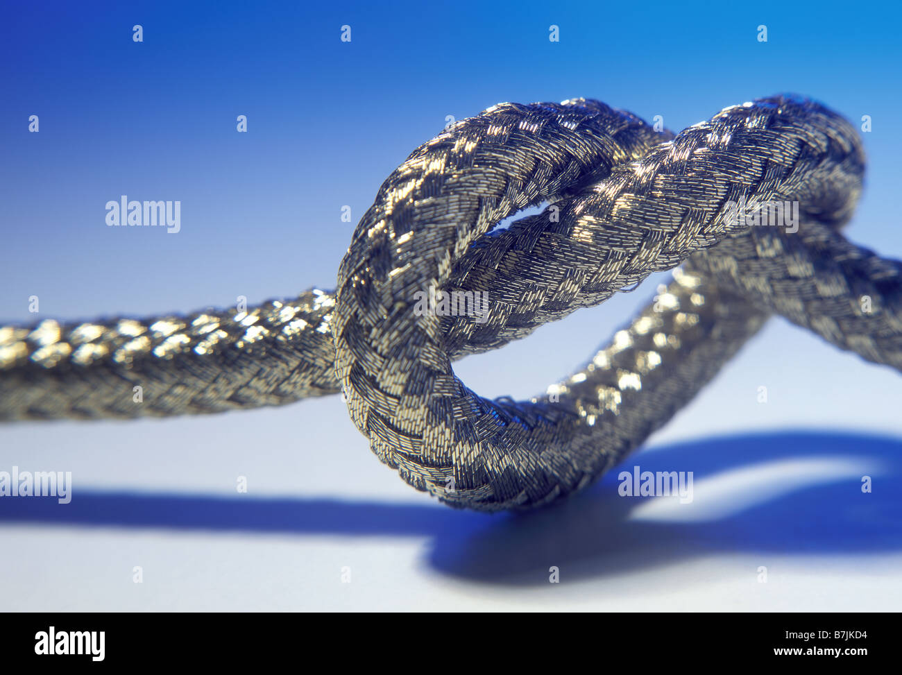 Verknoteten Seil auf blauem Hintergrund Stockfoto