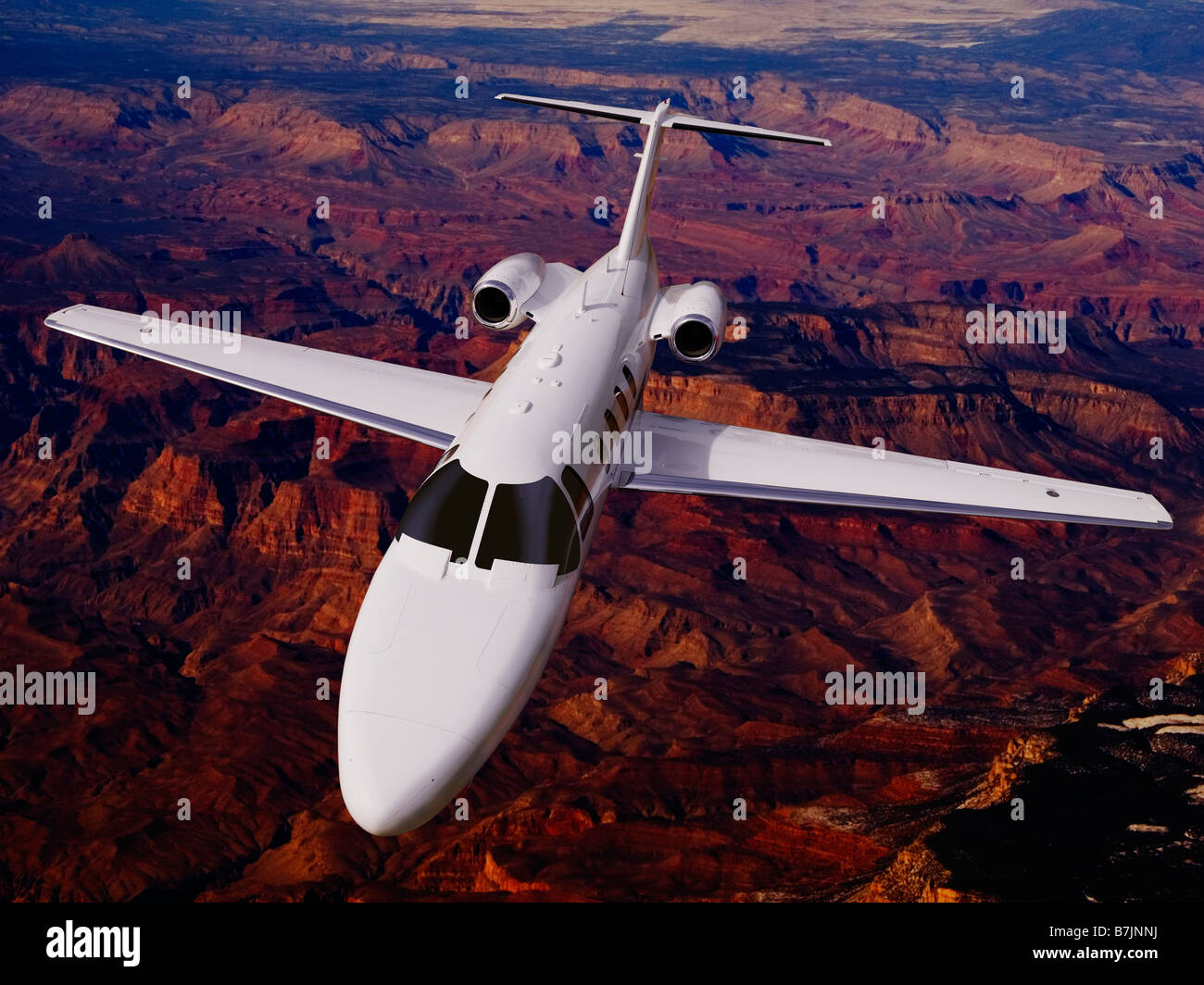 In einem zusammengesetzten Foto, eine Cessna CJ 1 Business-Jet fliegt mühelos über zerklüfteten, einsamen Bergen im Westen der USA Stockfoto