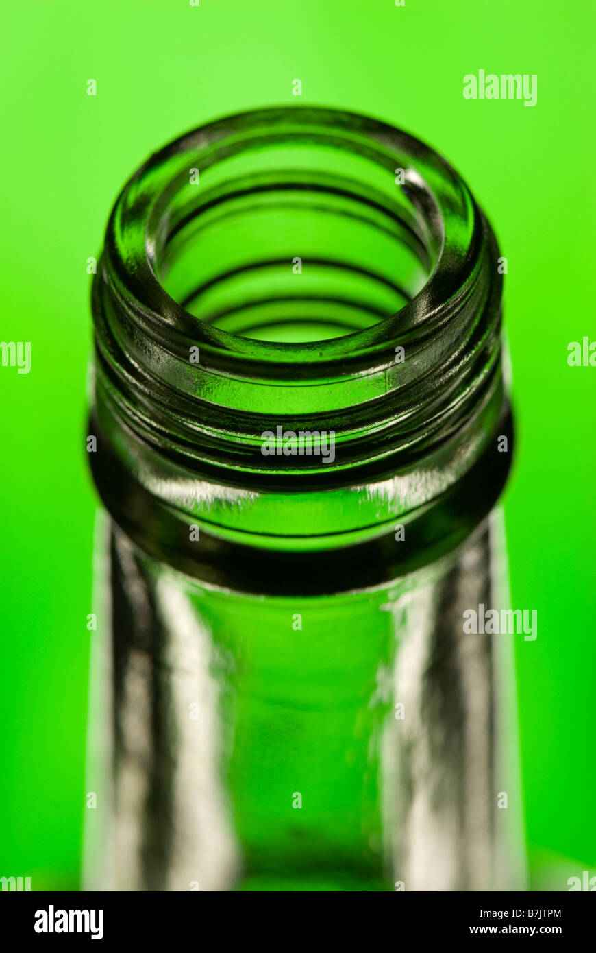 Spitze des leeren durchsichtiger Glasflasche mit grünem Hintergrund Stockfoto
