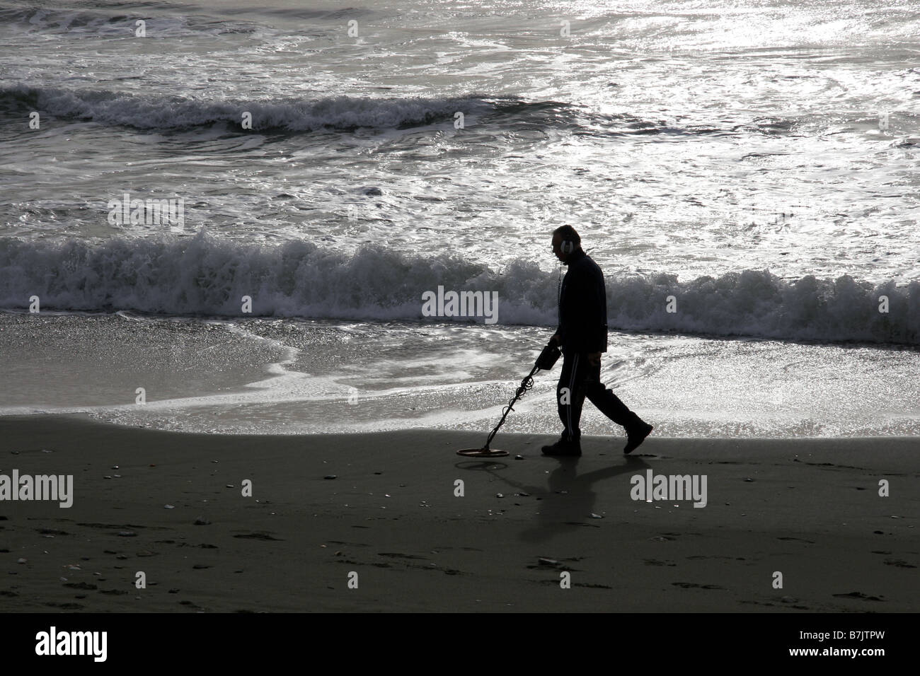 Mann am Strand mit Metalldetektor Stockfoto