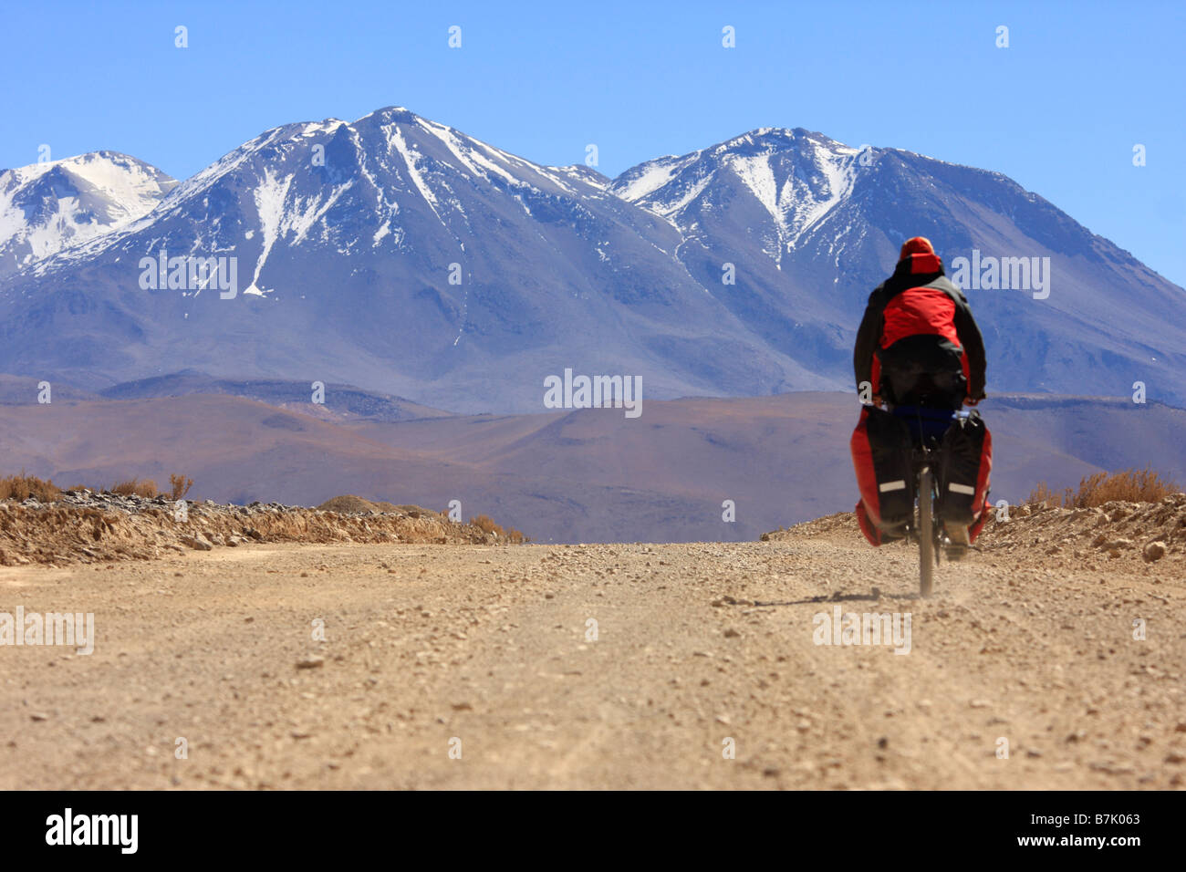 Ein Mann ist unter sehr harten Bedingungen in den Anden in der Nähe von Ollague Antofagasta Region Chile Radfahren. Stockfoto