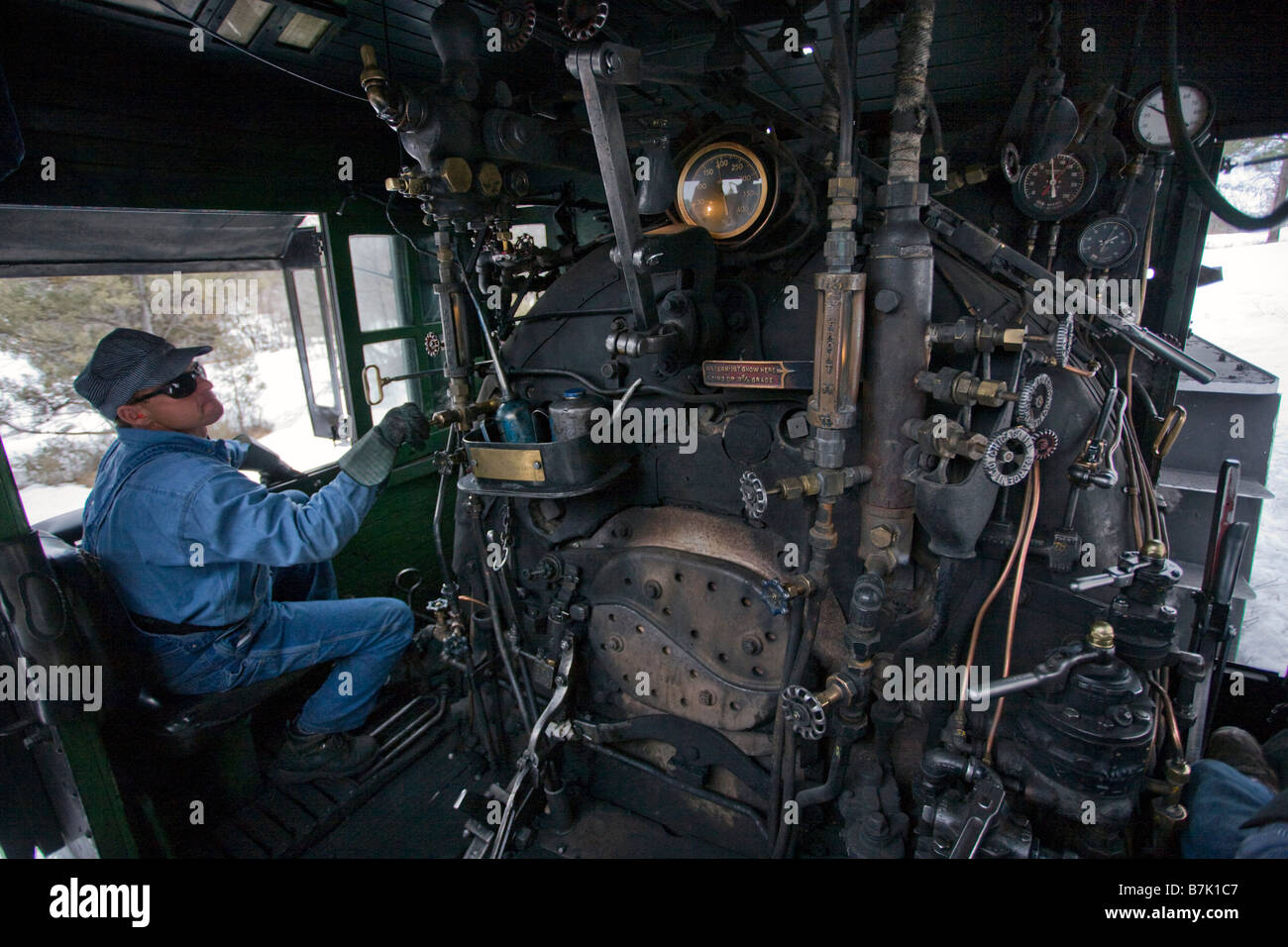 Feuerwehrmann prüft Messgeräte in einer Dampflokomotive auf die Durango Silverton Narrow Gauge Railroad, Colorado Stockfoto