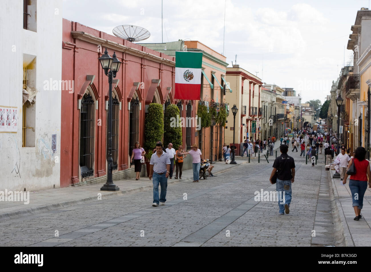 Oaxaca, Mexiko. Straße Szene, mexikanische Flagge, Calle Alcalá, mit Blick auf den Zócalo (Town Plaza) in der Ferne. Stockfoto