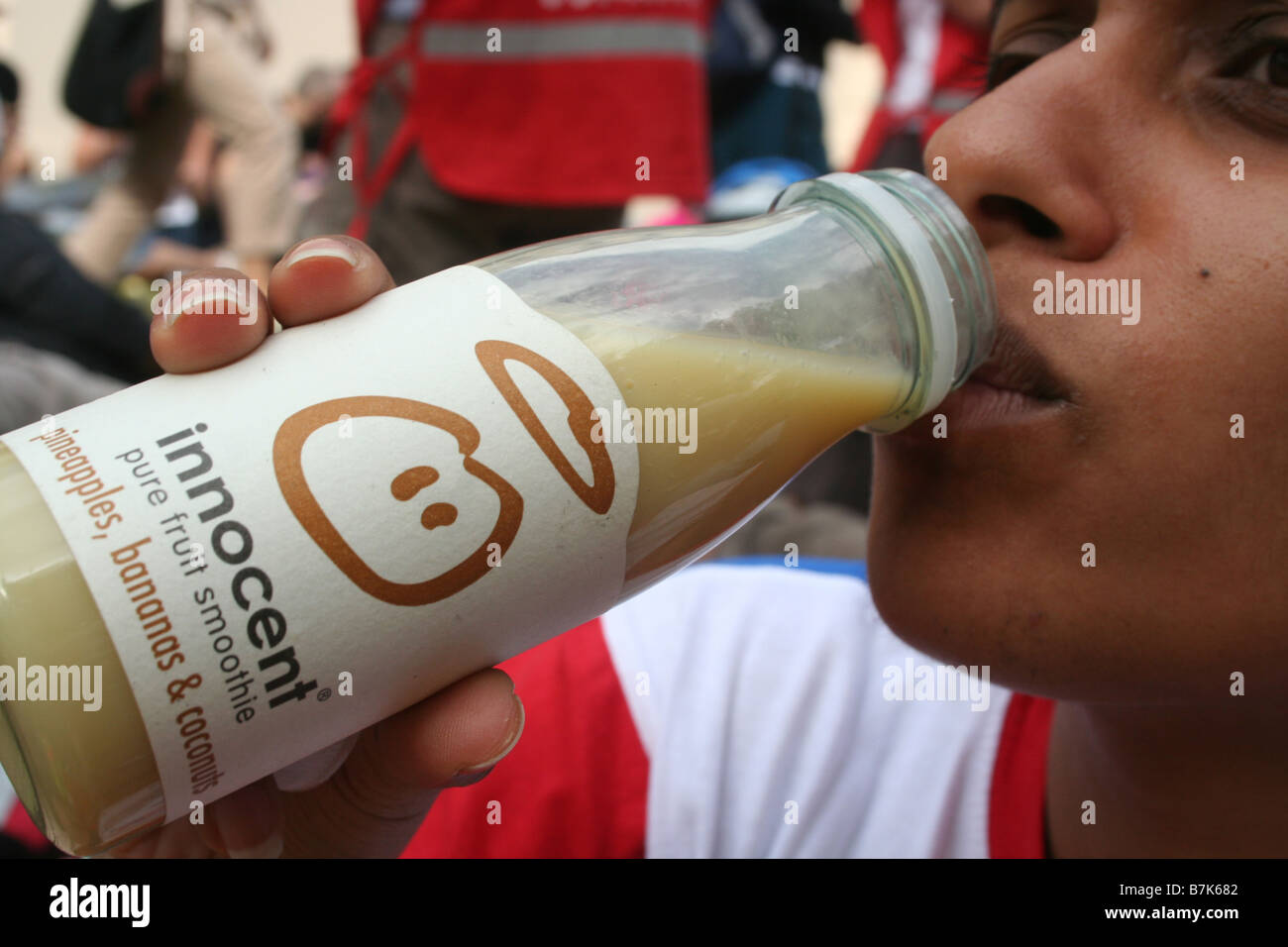 Frauen, die einen Innocent Smoothie Fruit Drink trinken Stockfoto
