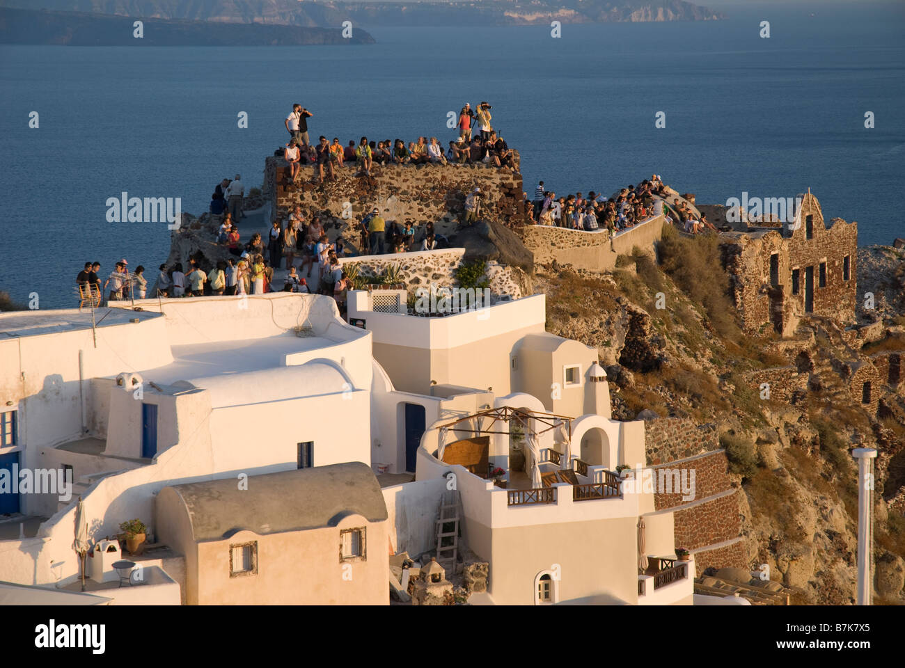 Griechenland, Santorini, Oia. Besucher kommen in den westlichen Punkt der Oia um den Sonnenuntergang zu beobachten. Stockfoto