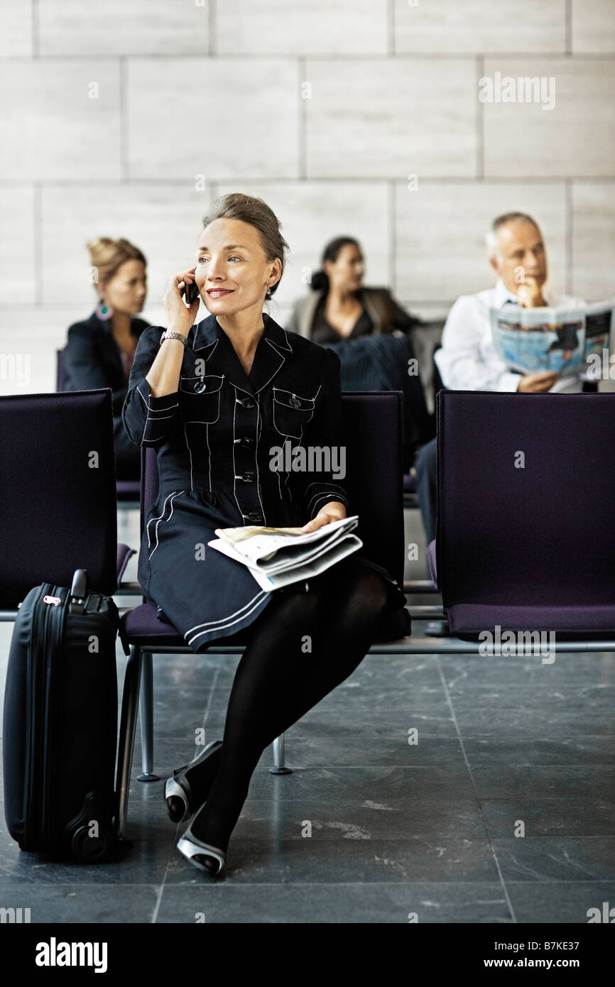 Frau mit einem Koffer, auf dem Handy Stockfoto