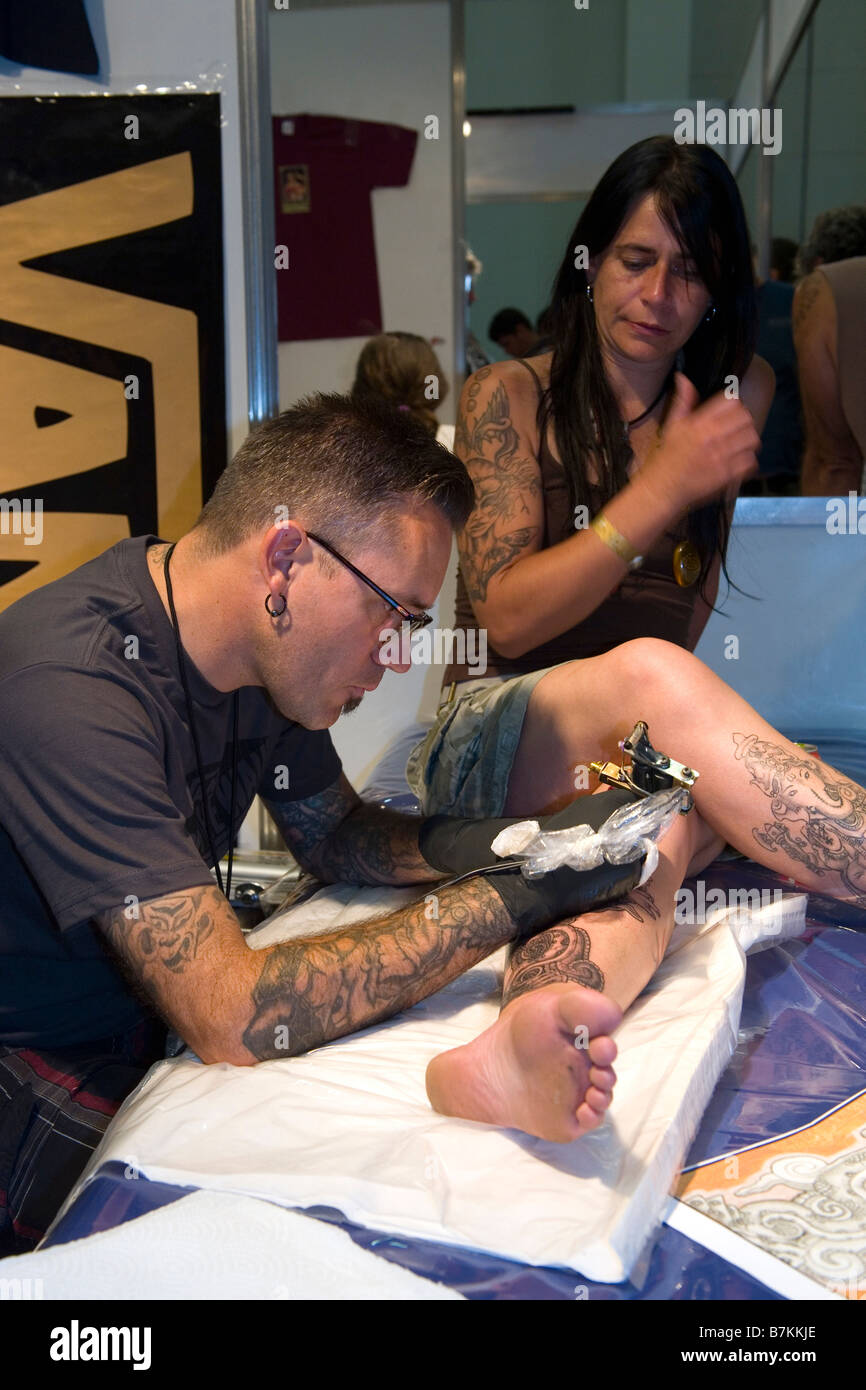 Tattoo-Künstler mit Kunden im südlichen Ink Xposure Tattoo Convention in Südafrika Stockfoto