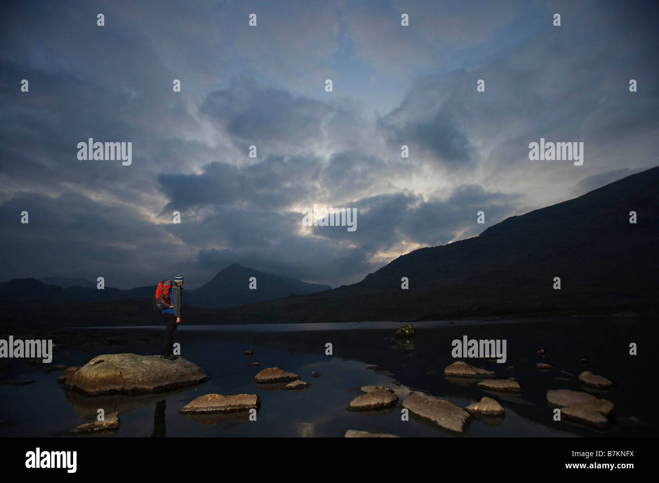 Wanderer auf Felsen in einem See stehen. Stockfoto