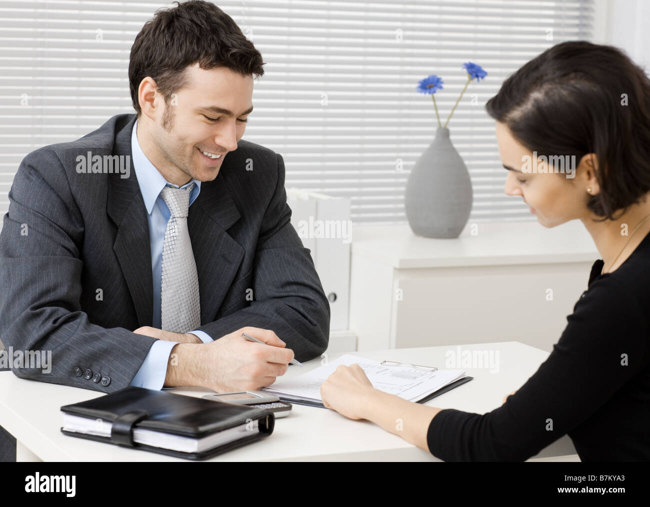 Glückliche junge Berater Kaufmann consulting bei Büro lächelnd Stockfoto