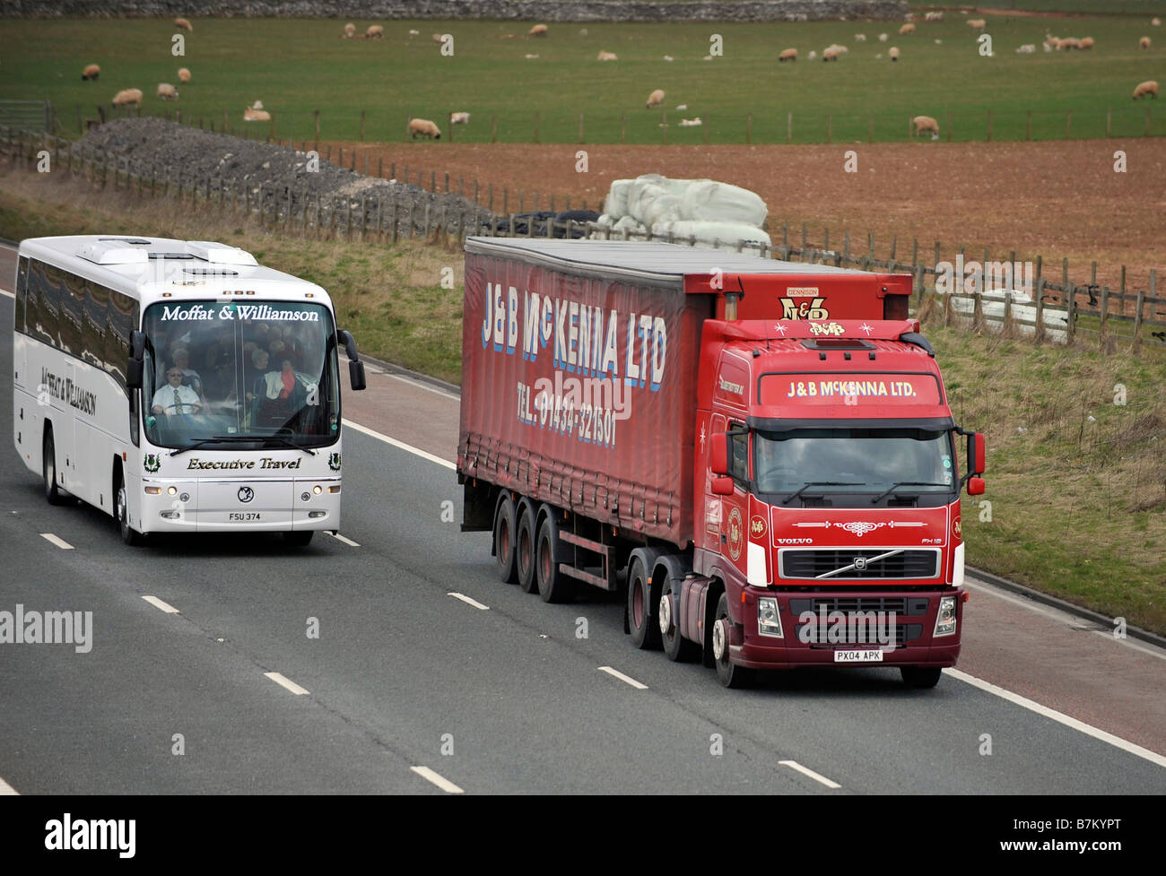 Moffat und Williamson Trainer überholt einen drei Achs Volvo FH Lkw mit roten Curtainsided Tri achsiger Anhänger J B McKenna transport Stockfoto