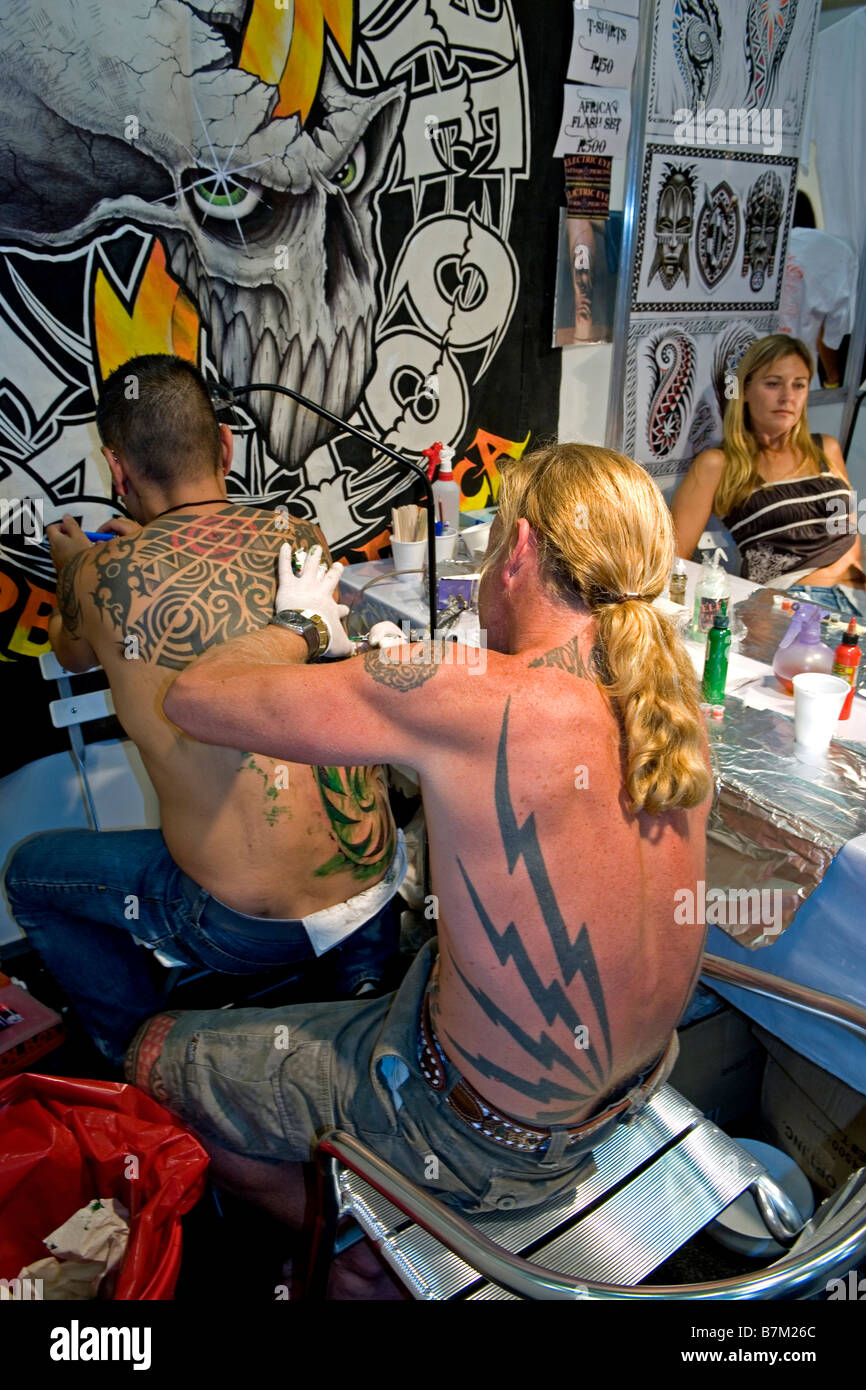 Tattoo-Künstler mit Kunden im südlichen Ink Xposure Tattoo Convention in Südafrika Stockfoto