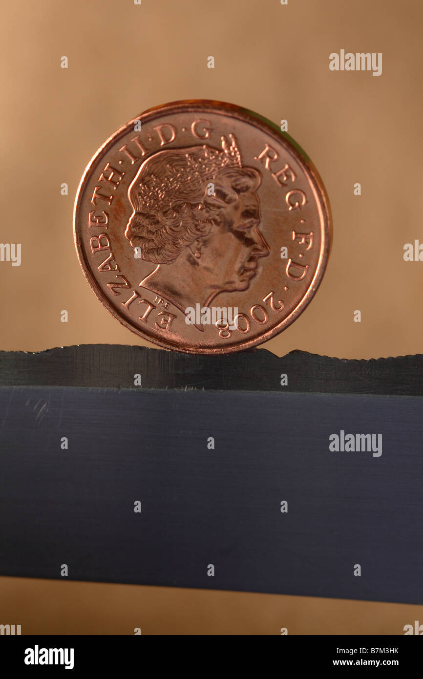 Britische 1 p 1 Pfennig Geld Münze auf ein Messer Kante Finanzkonzept der Unsicherheit Risikowert ausgeglichen Stockfoto