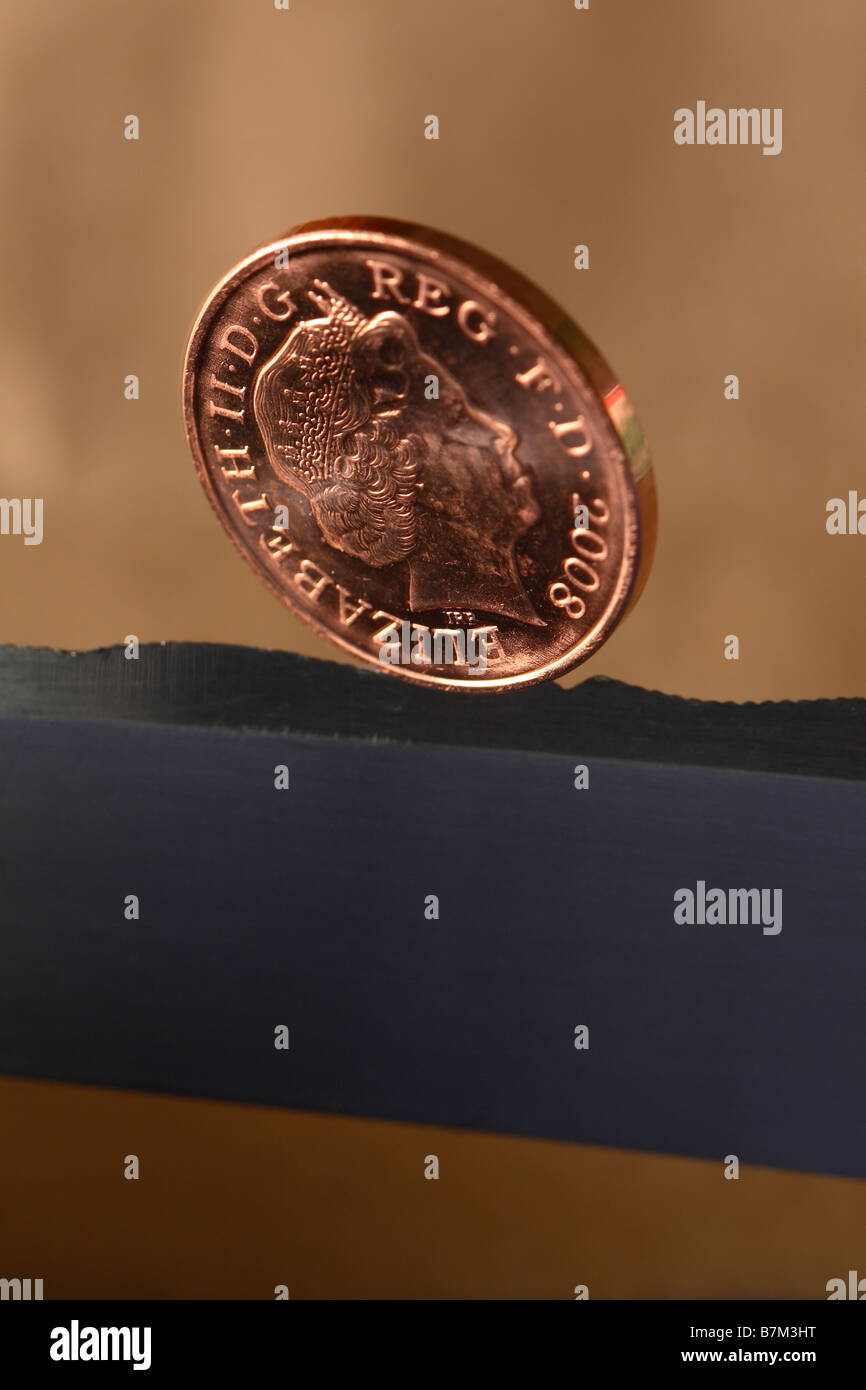 Britische 1 p 1 Pfennig Geld Münze balanciert auf einer Messer-Rand-Finanzkonzept Stockfoto