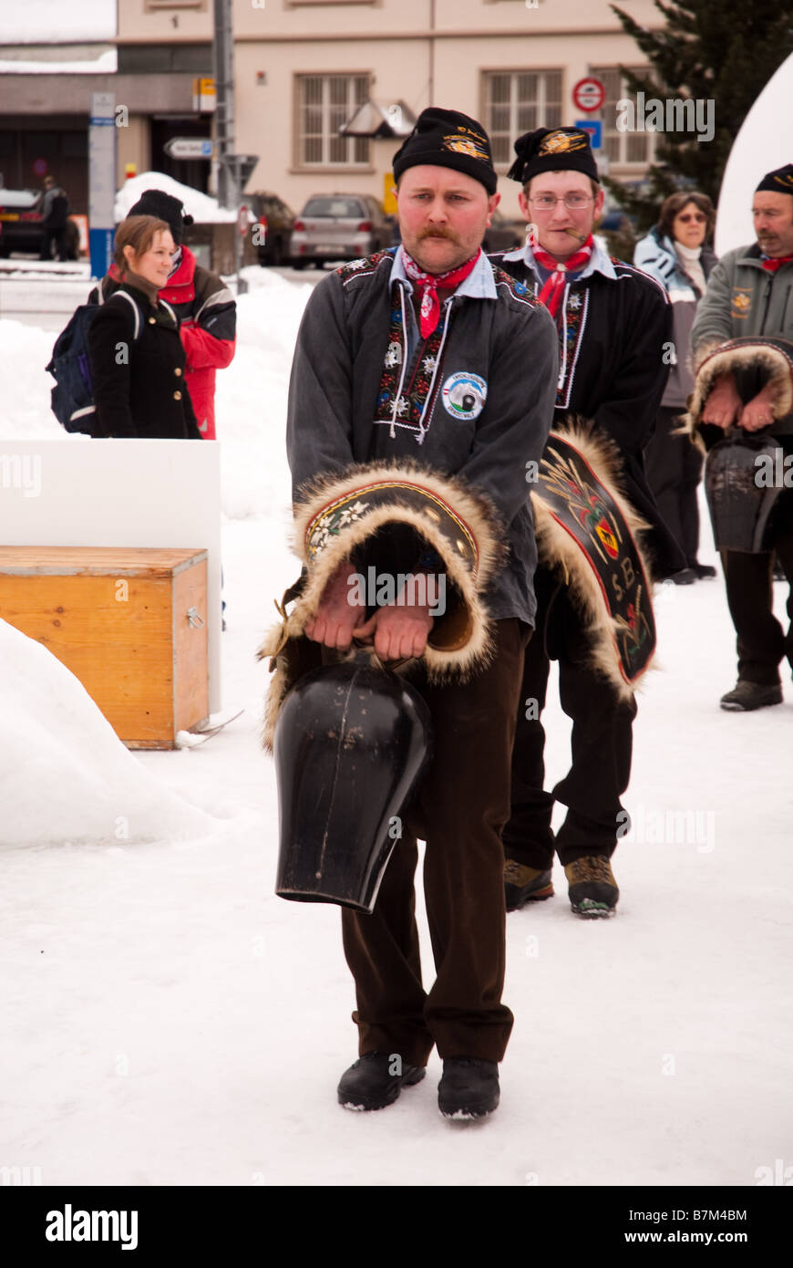 Prozession der Männer in traditionellen Schweizer Kostüm Läuten der Kuhglocken auf World Snow Festival in Grindelwald Schweiz Stockfoto