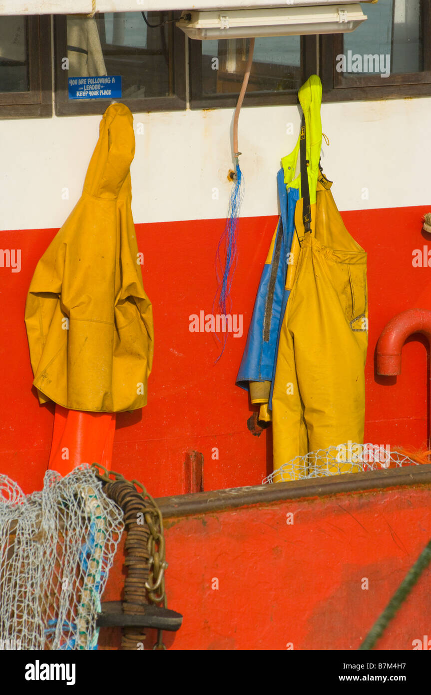 Fishermans gelb Regenschutz Hung auf der Rückseite des Steuerhauses eine kommerzielle Fischerei Boot wasserdichte Kleidung Stockfoto
