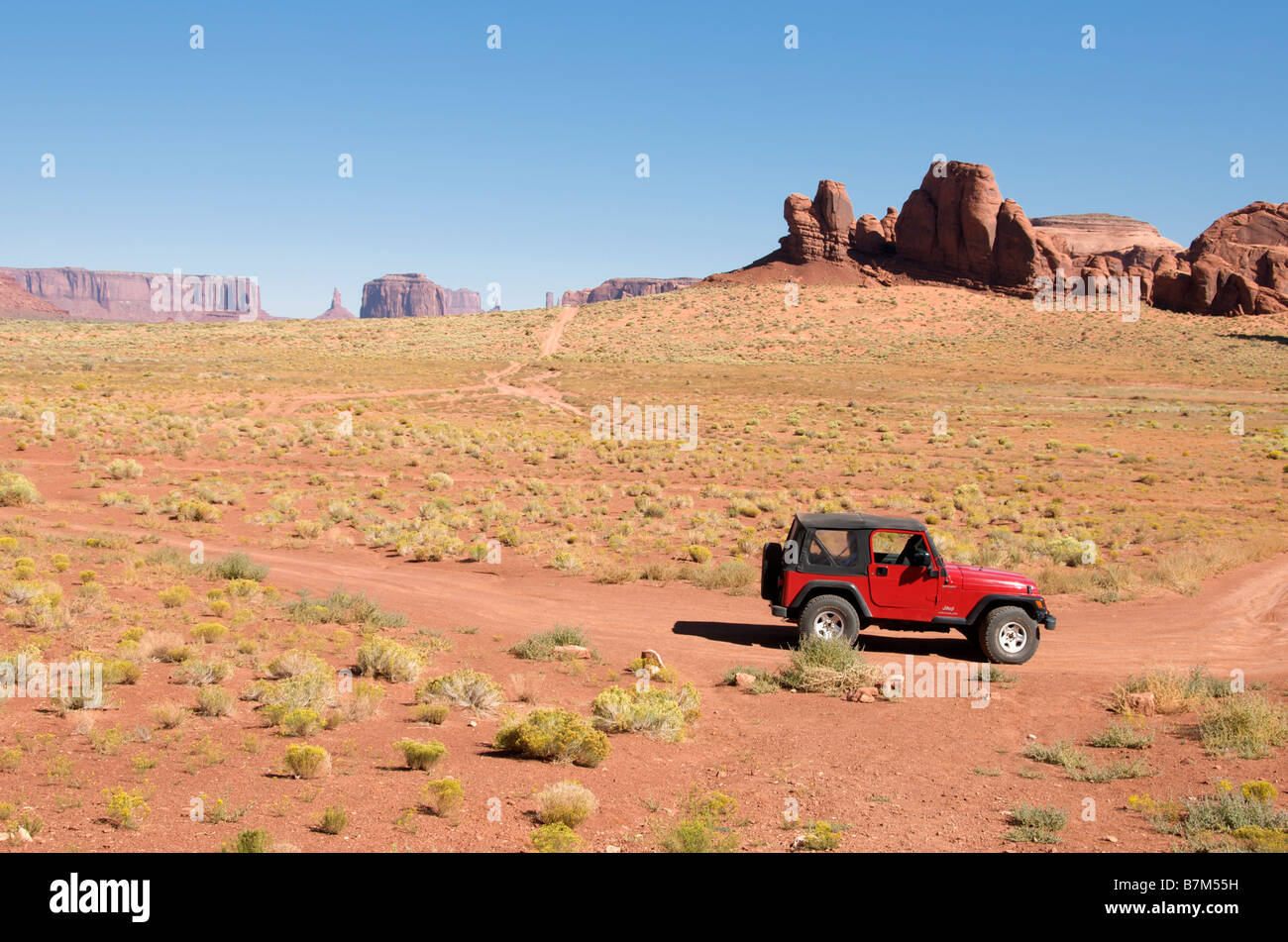 Roter Jeep mit Tafelberge und Spitzkuppen als Kulisse Monument Valley Navajo Tribal Park Arizona USA Stockfoto