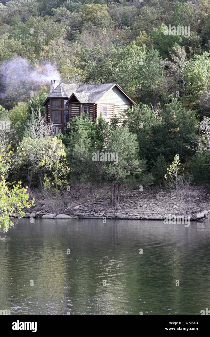 Ein Blockhaus auf einem Felsen über dem See während der Falljahreszeit in Branson Missouri Stockfoto