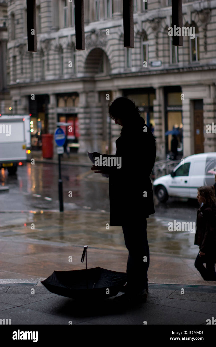 Regen Sie im Londoner Finanzviertel Büroangestellter schützt vor Regen während Platzregen in der City of London Stockfoto