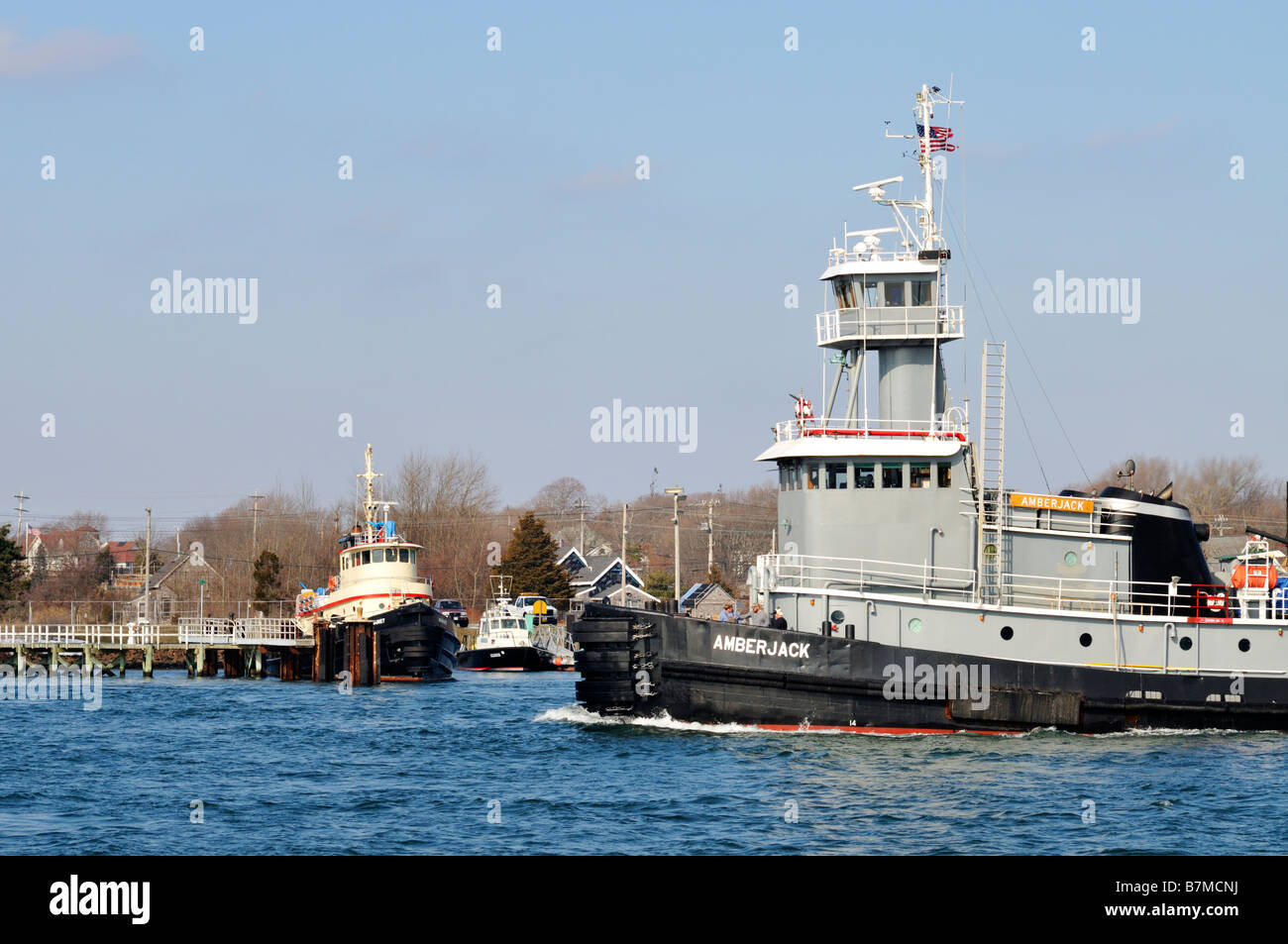 Eine graue Schlepper, vorbei an einem anderen angedockten Schlepper Stockfoto