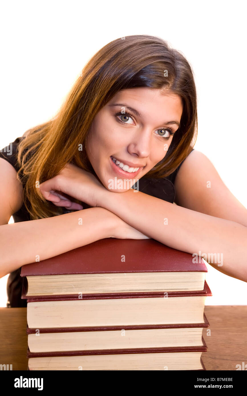Eine junge Frau legt ihren Kopf auf einem Stapel Bücher Stockfoto
