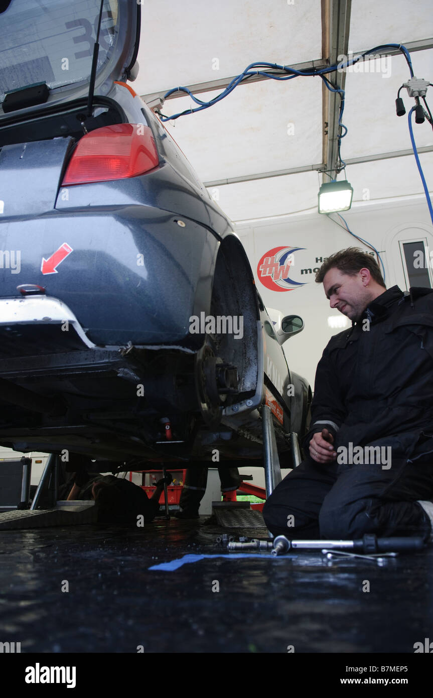 Kfz-Mechaniker untersucht hinteren Radhaus des Autos Stockfoto