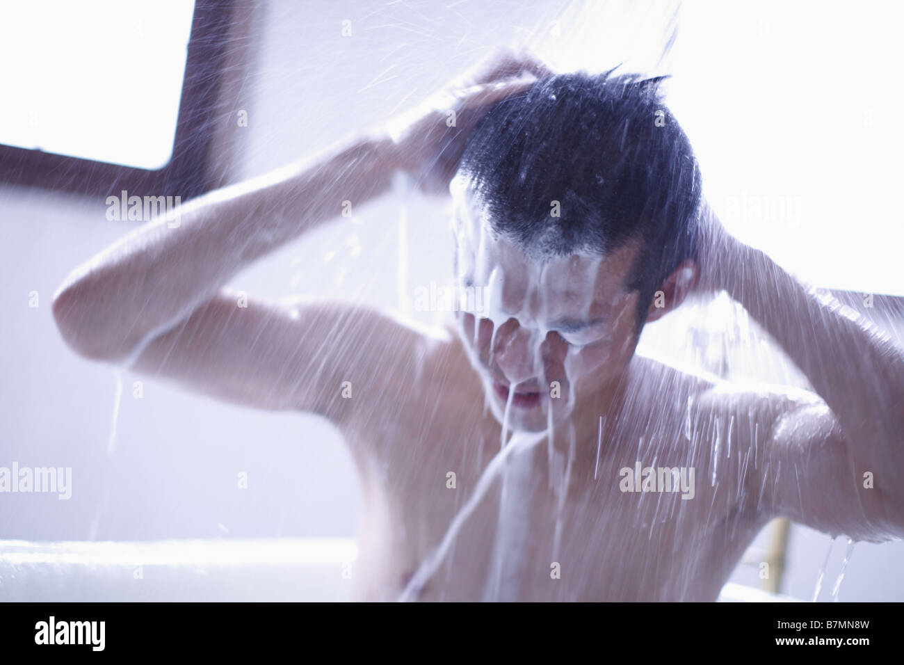 Mann Waschen Haare in der Dusche Stockfoto