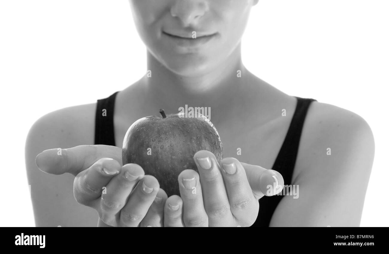 Schöne junge Frau, die über weißen roten Apfel essen Stockfoto