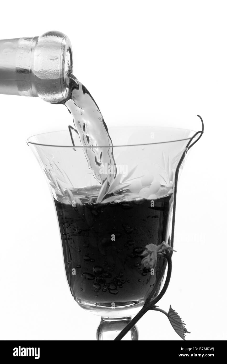 Rotwein aus einer Flasche Wein in Strömen Stockfoto