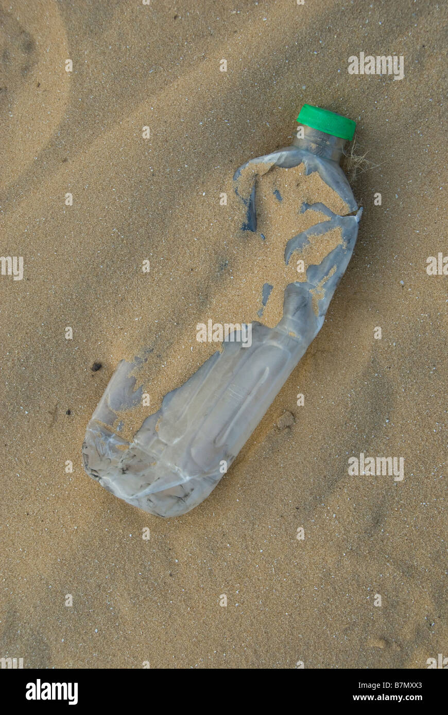 Eine leere zertrümmerte Kunststoff Trinkflasche in einem sandigen Strand Stockfoto