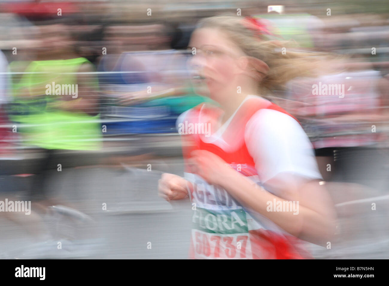 Frau rennt den London-Marathon am Damm. Sie ist unscharf, um das Fasten zu betonen Tempo. Stockfoto