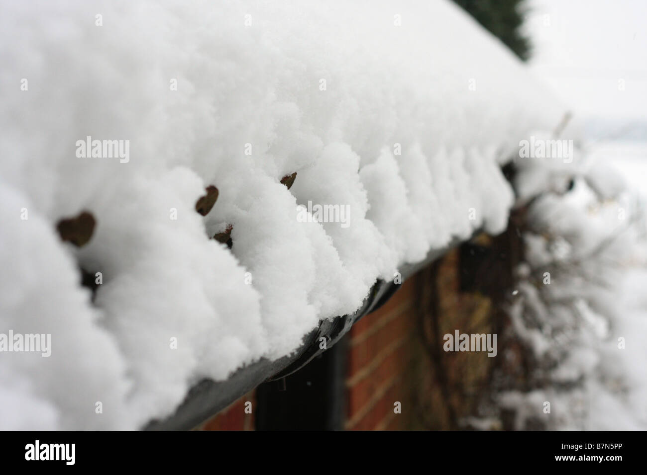 Schnee und Eis, aufgebaut auf dem Dach und Dachrinnen von ein Plumpsklo. Stockfoto