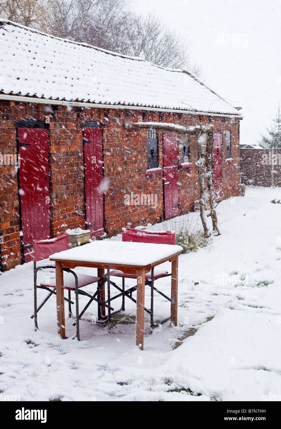Gartentisch und Stühle in frischem Schnee bedeckt Stockfoto